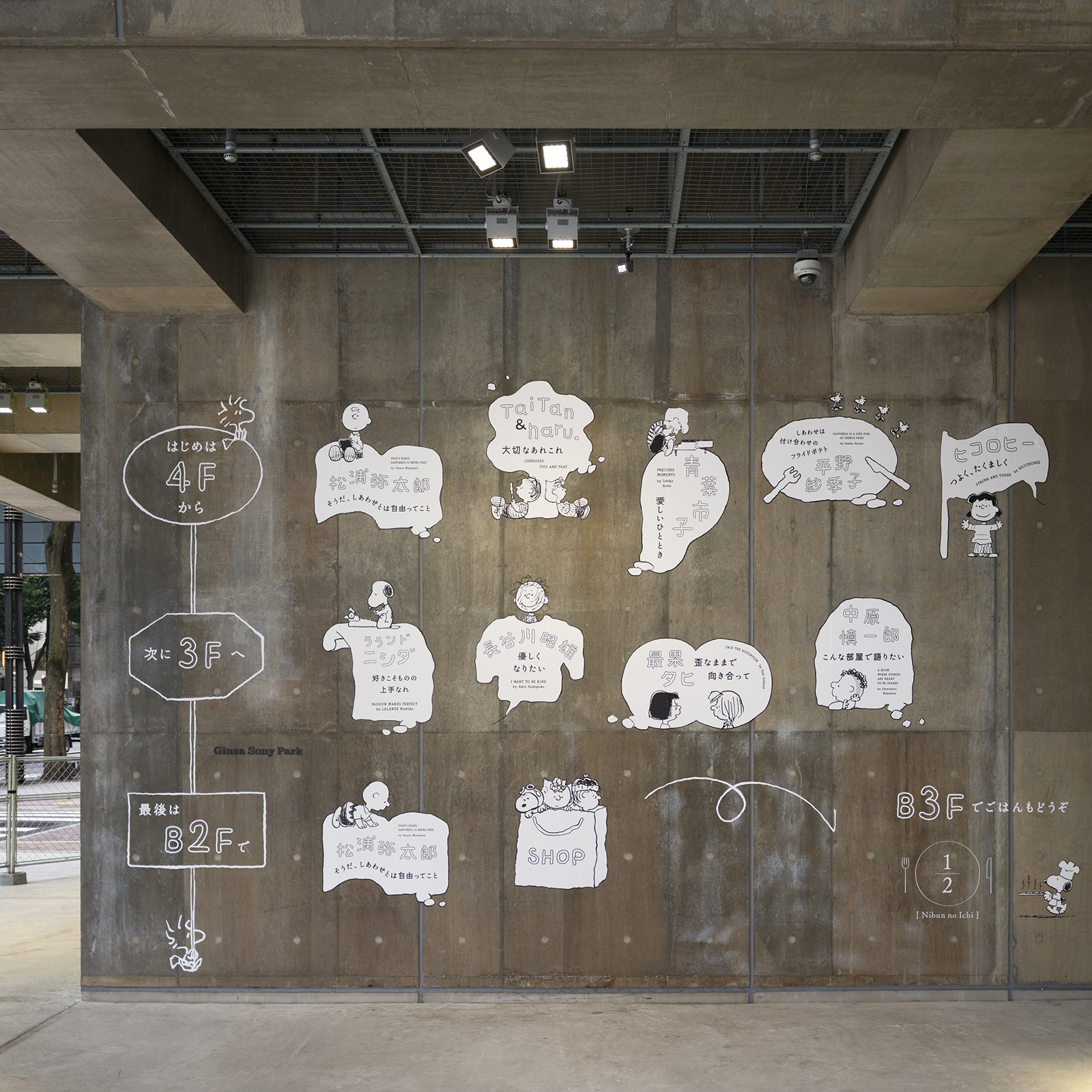 コンクリート壁に描かれた吹き出しとキャラクターたちが、展示や店舗の案内を伝えている。