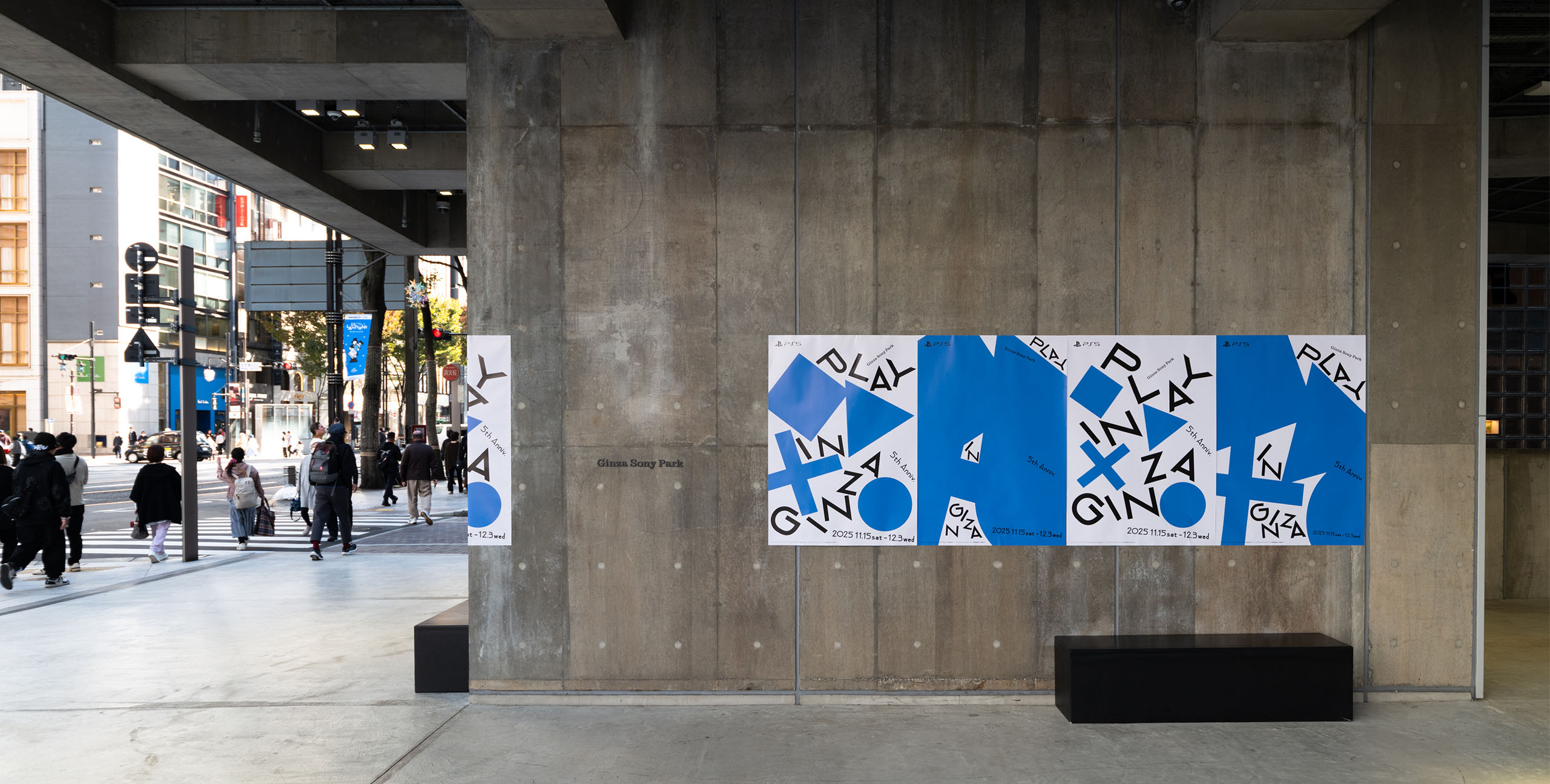 晴海通りに面したGinza Sony Parkのコンクリート壁面に、青と白の「PLAY IN GINZA」のポスターが横一列に掲出されている。