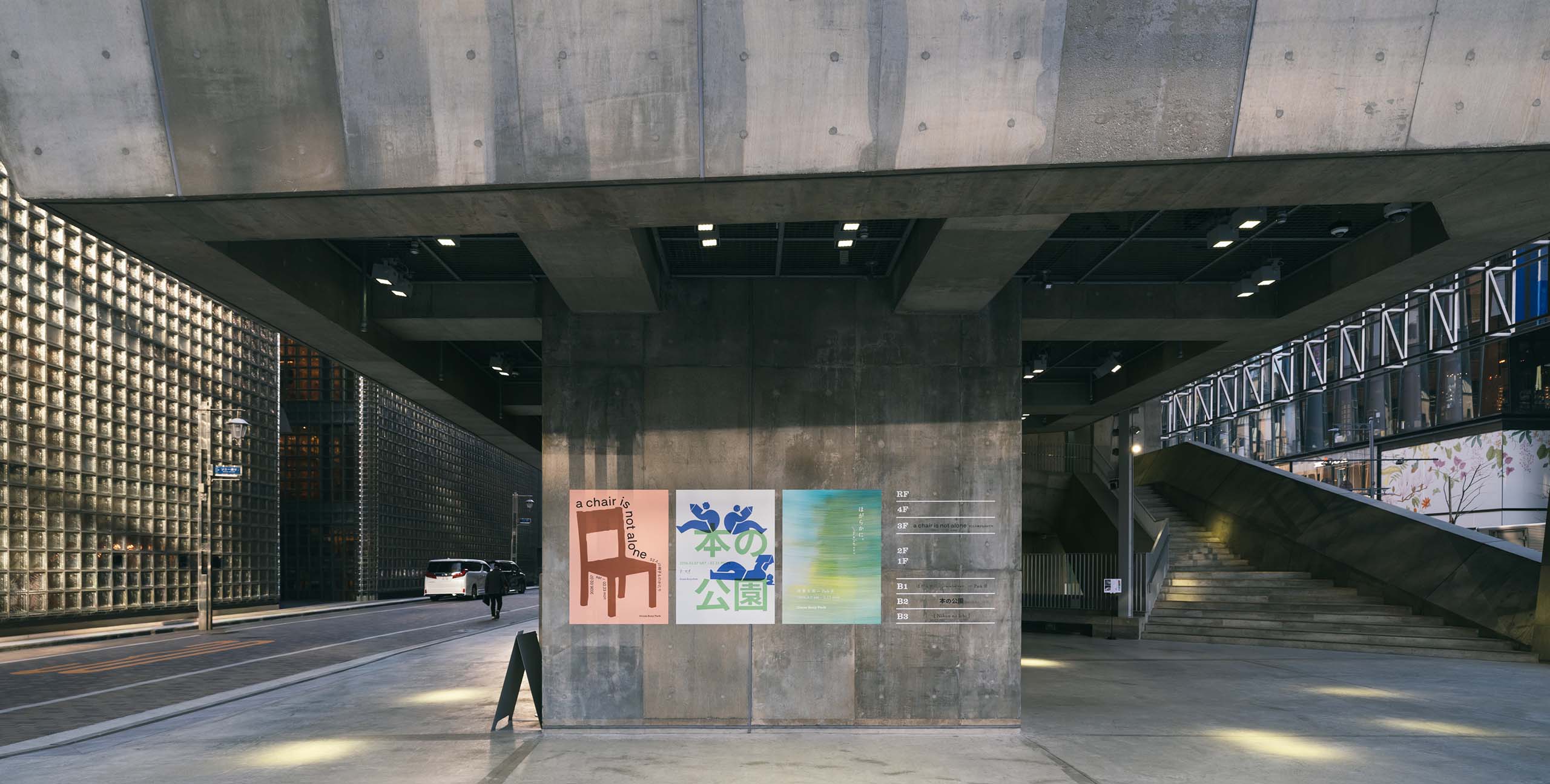 Ginza Sony Park外観。コンクリートの柱に掲示されたポスターと階段空間が、都市と公園の境界を静かに示している。